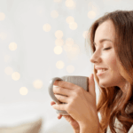 Mulher sorrindo e segurando uma xícara de café, representando a tranquilidade de quem aprendeu como conseguir backlinks de graça para seu site.