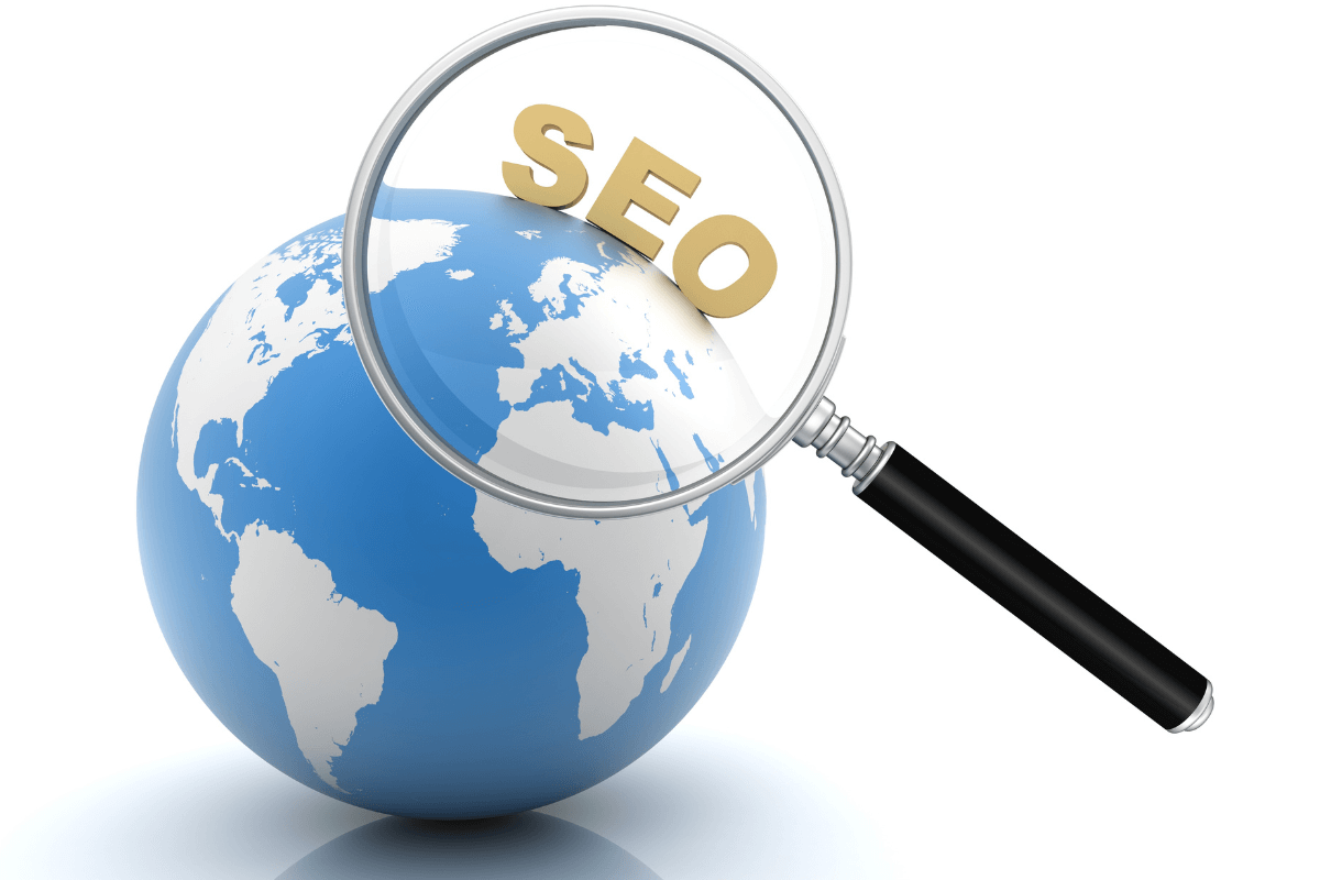 SEO: A ferramenta para encontrar tráfego qualificado Lupa ampliando a sigla SEO sobre um globo terrestre, ilustrando como a otimização de busca localiza e atrai tráfego qualificado em meio à imensidão da internet.