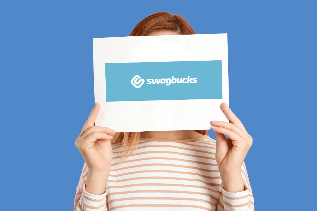 Pessoa segurando um cartaz com o logotipo oficial da plataforma, ilustrando o guia completo sobre como ganhar dinheiro com a Swagbucks na internet.